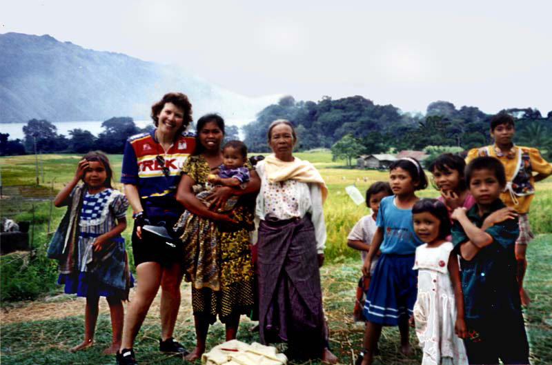 Touring cyclist in Sumatra with local villagers